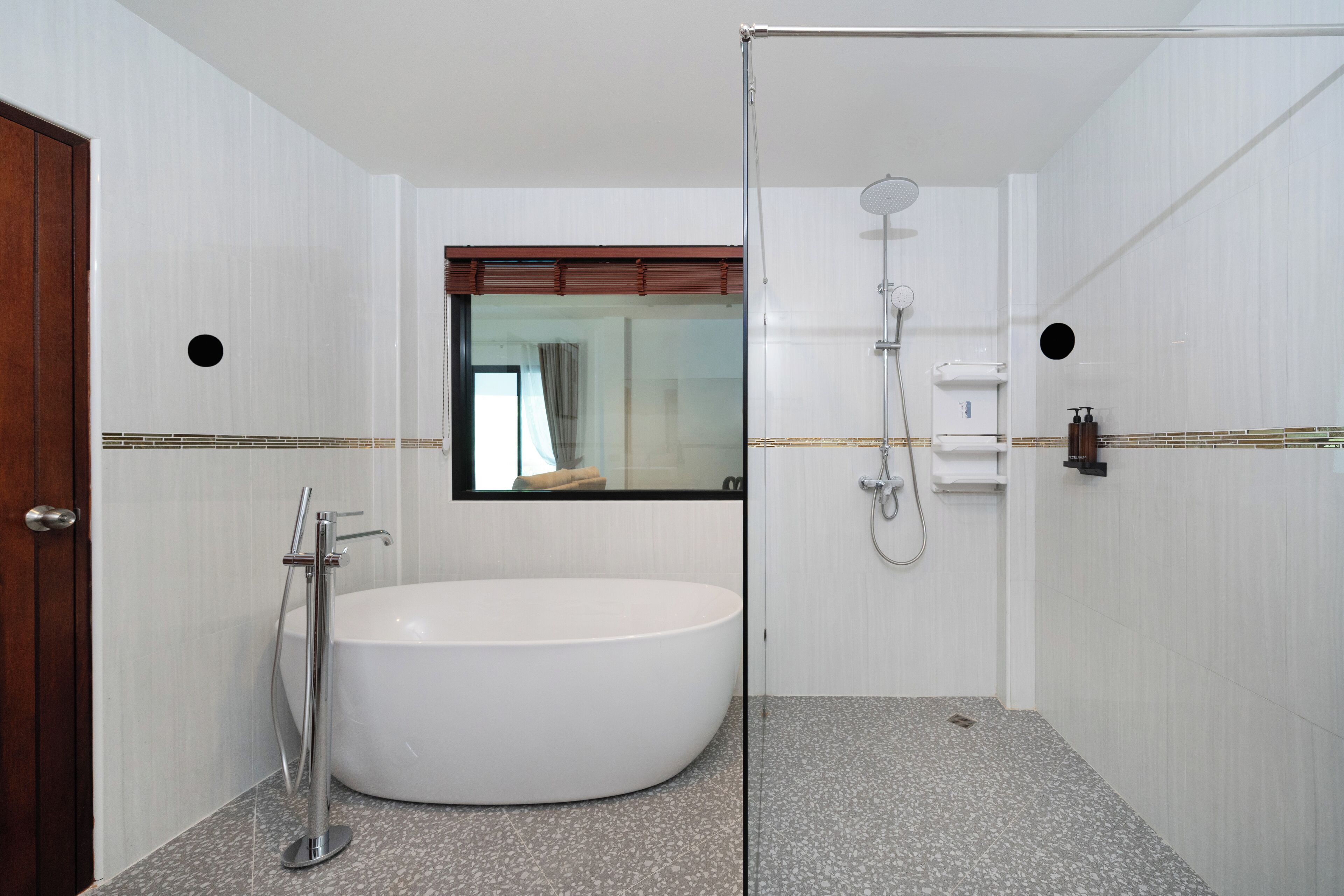A modern bathroom with a freestanding bathtub, a glass-enclosed shower, and a mirror above the sink.