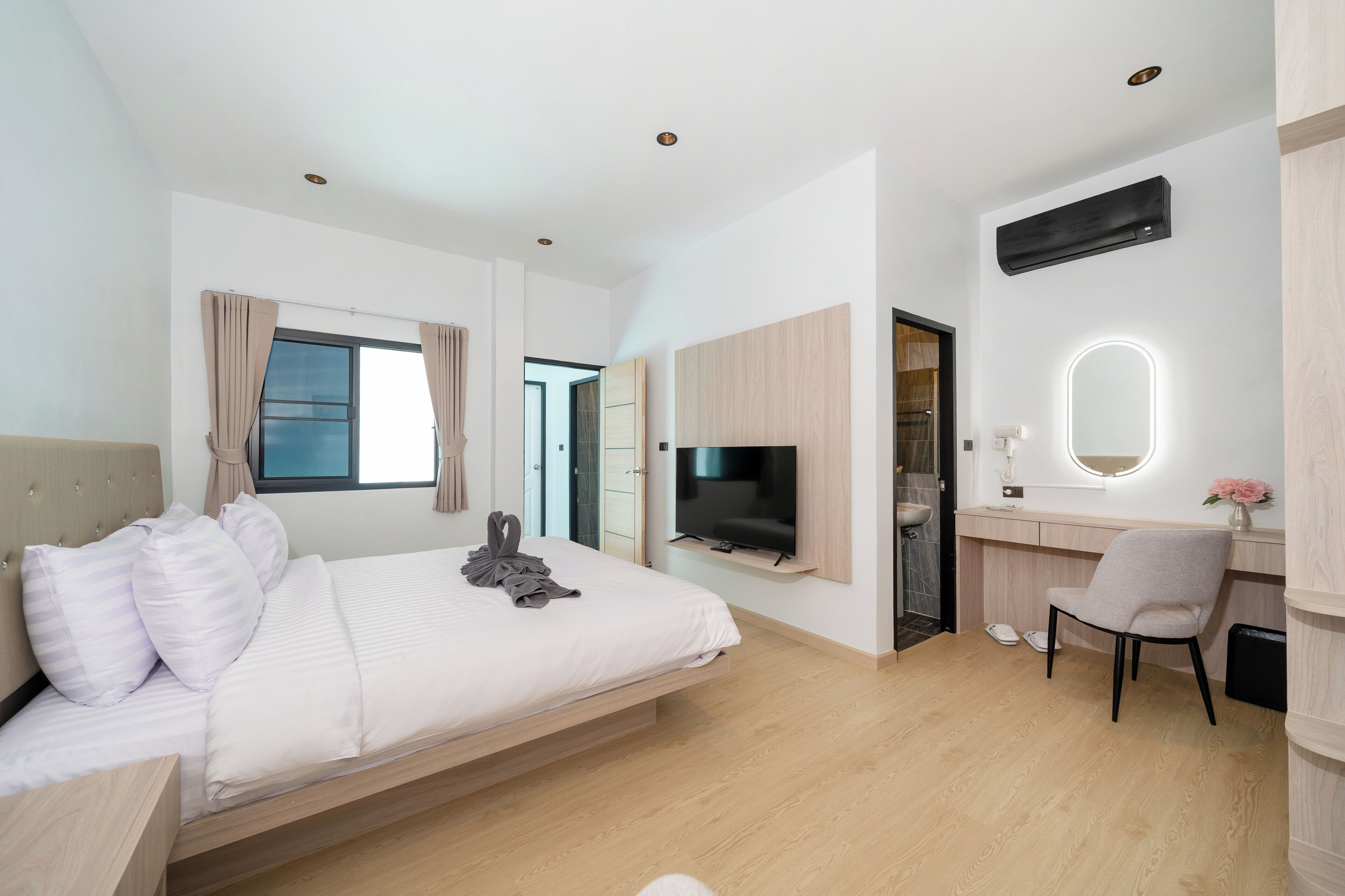 Ein modernes Hotelzimmer mit Bett, Schreibtisch, Fernseher und Bad.