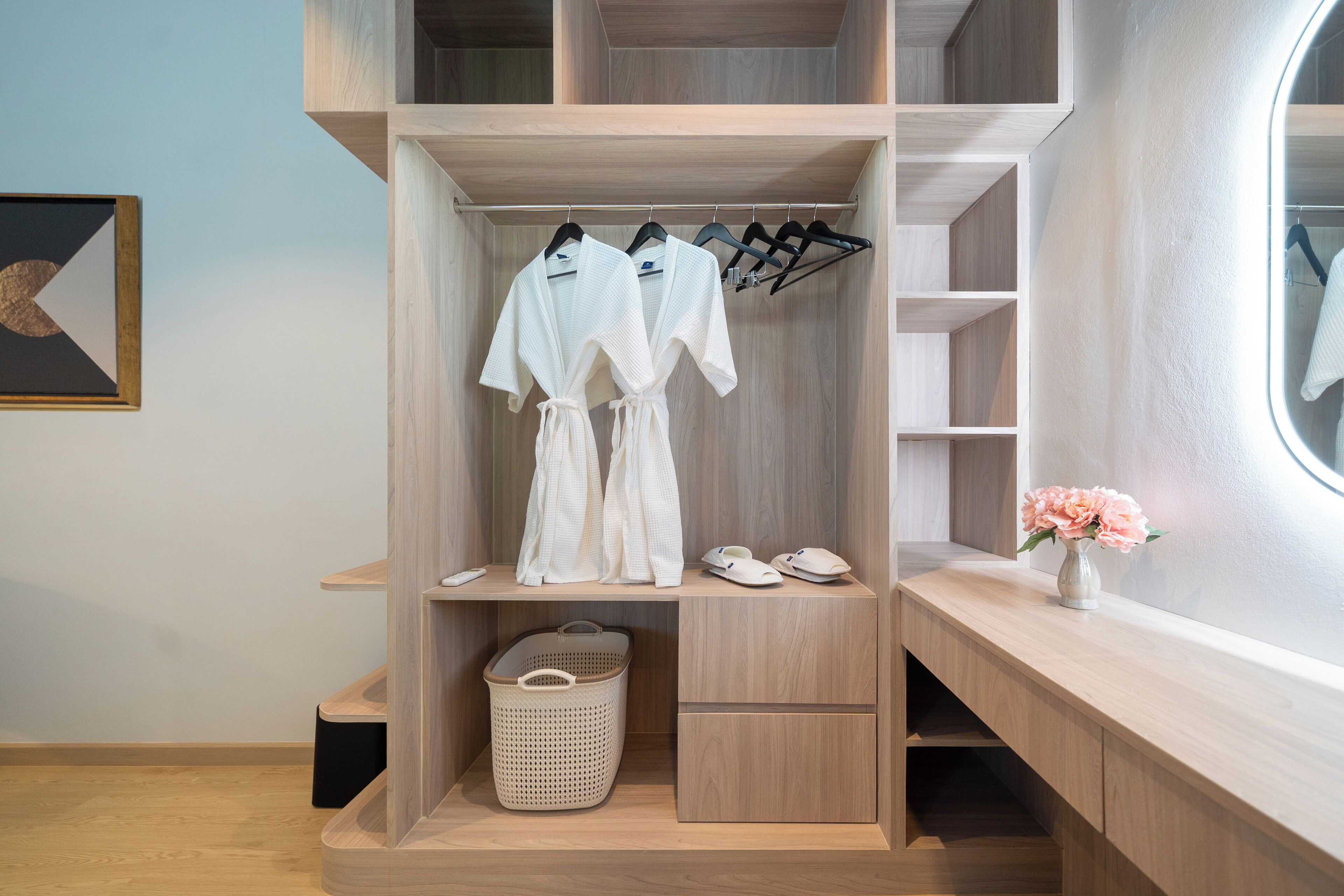 A modern closet with hanging space, shelves, and a basket.