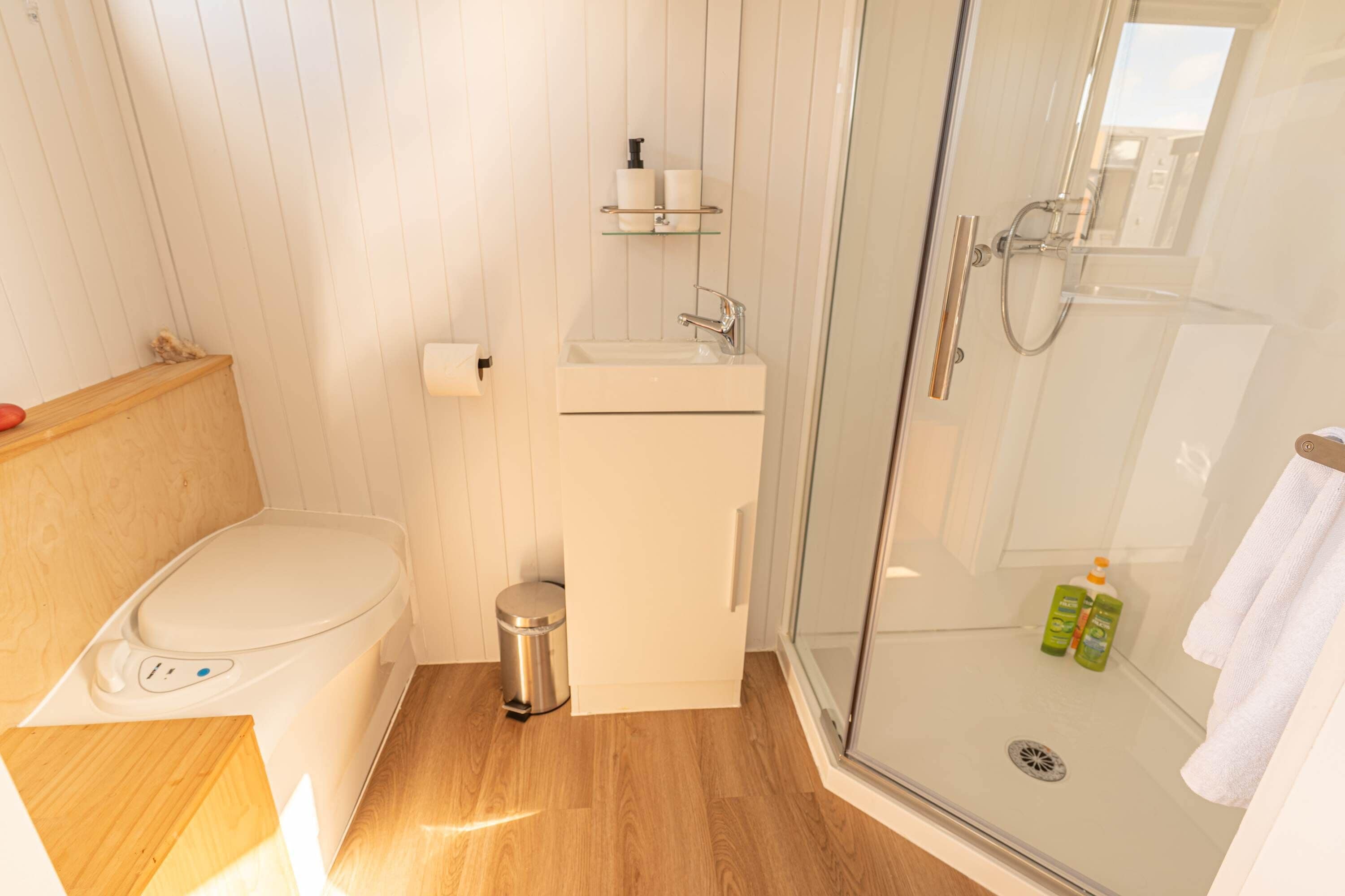A bathroom with a toilet, sink, and shower.