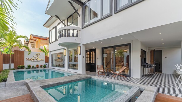 Ein modernes, zweistöckiges Gebäude mit Schwimmbad, Außenbereich und Balkon.