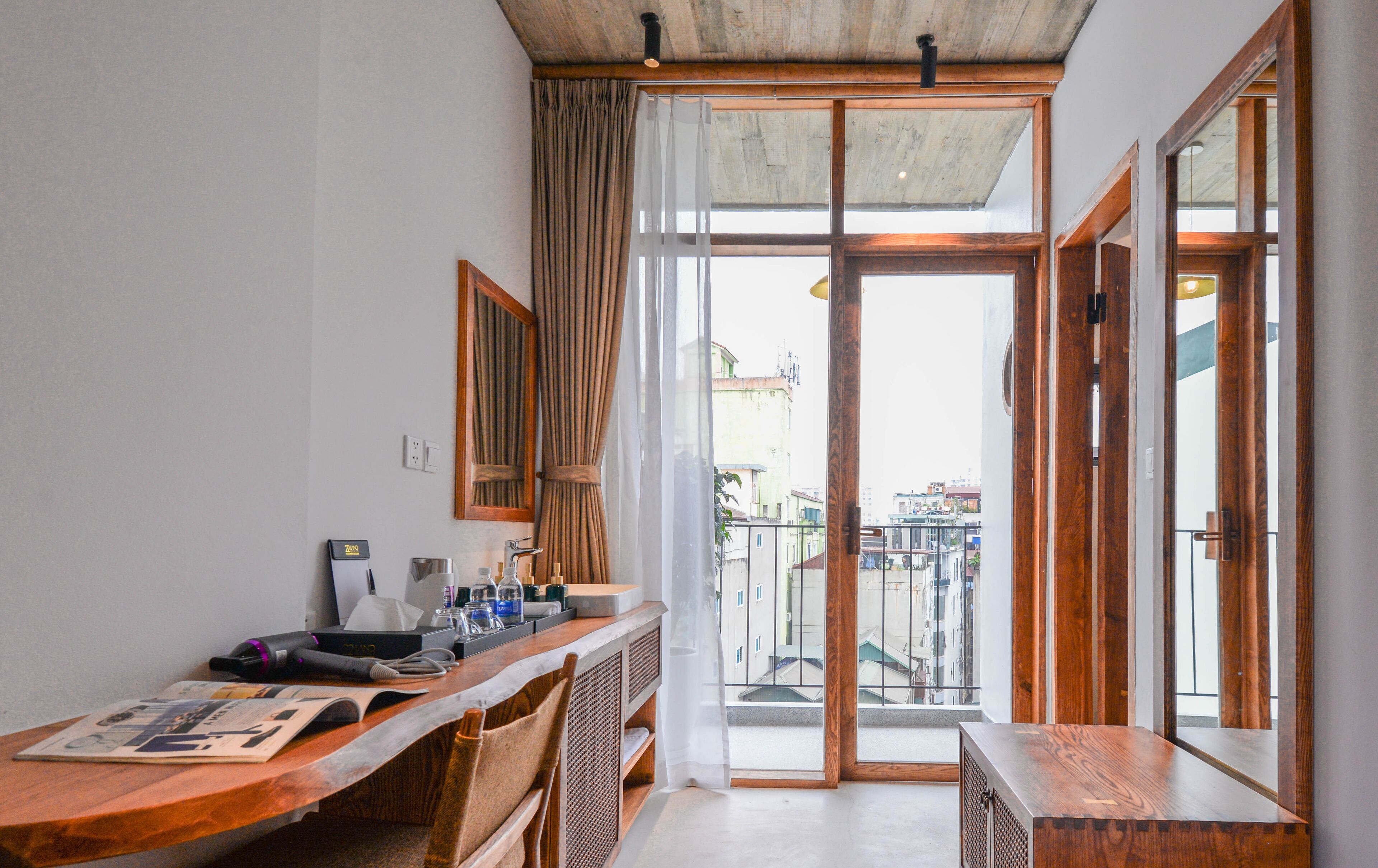 Cocina compacta con encimera de madera, un lavamanos y una ventana con cortinas.