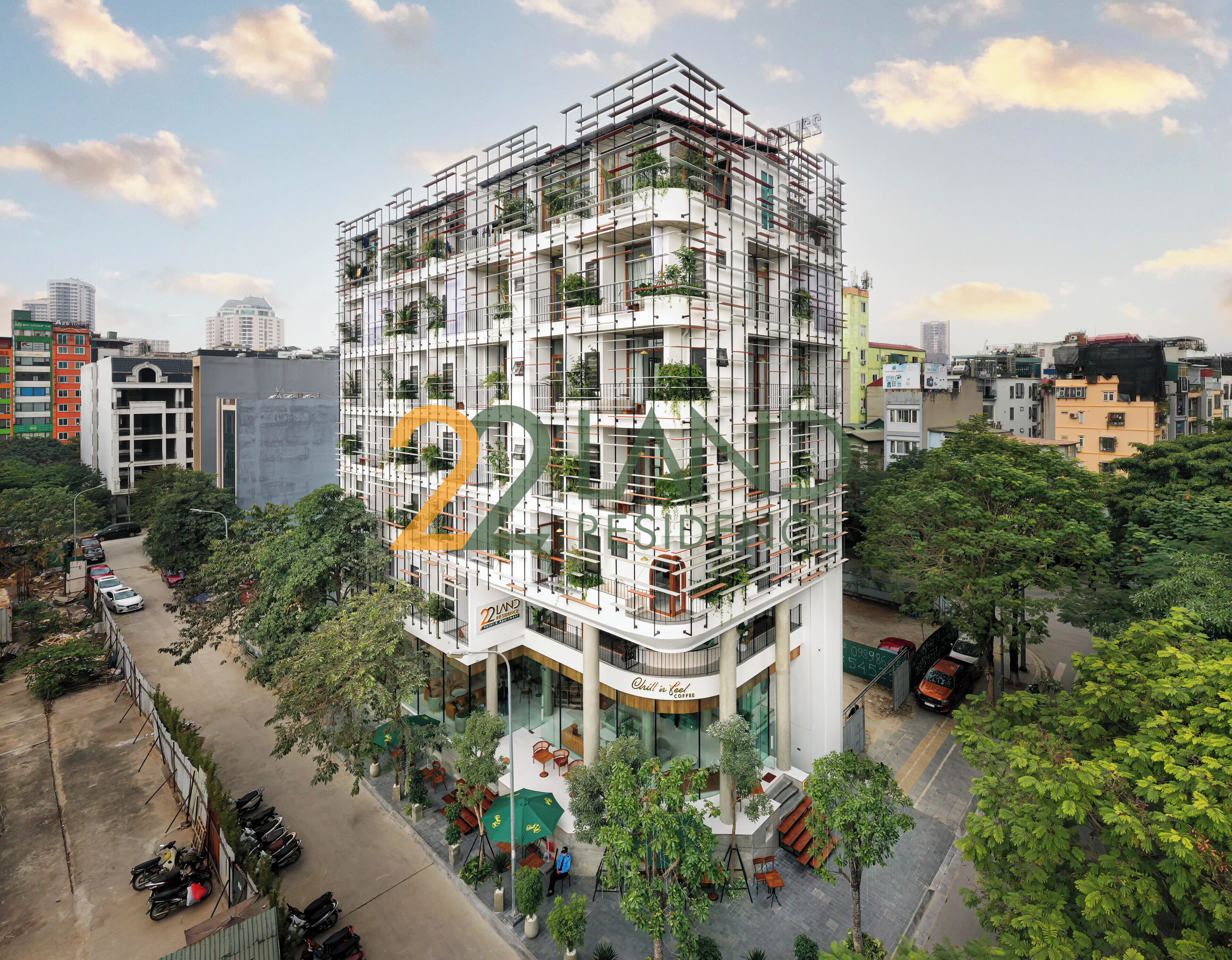 A multi-story building with balconies, a covered outdoor seating area, and a visible entrance.