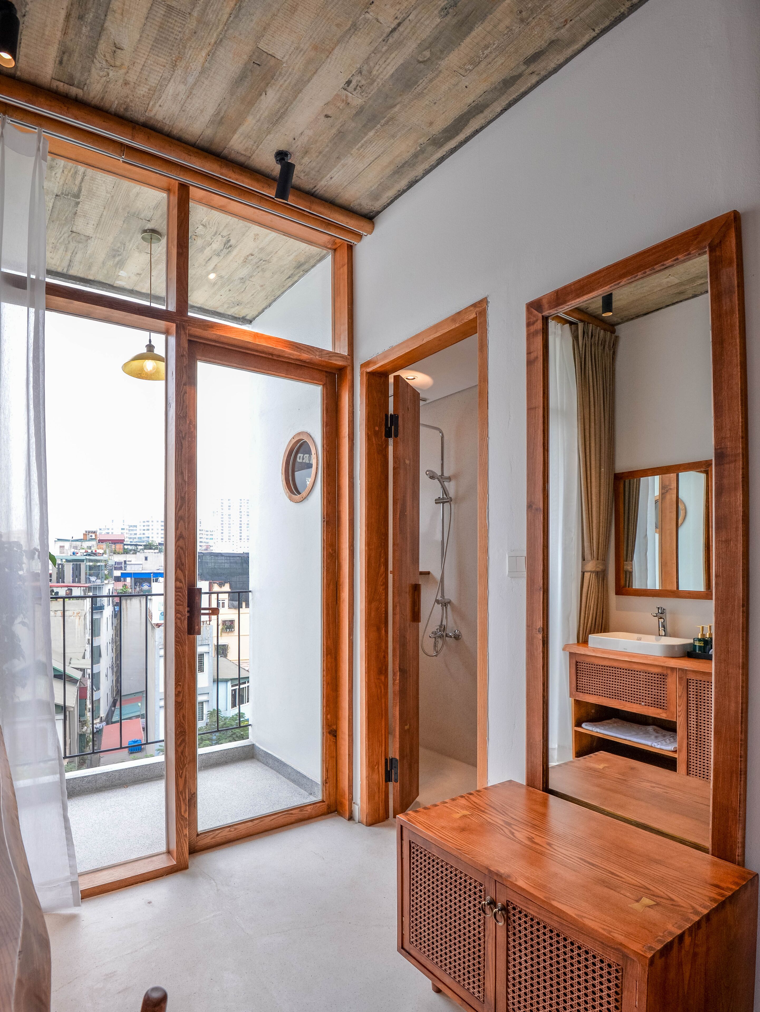 Une salle de bain moderne avec un meuble-lavabo en bois, un grand miroir et une douche.