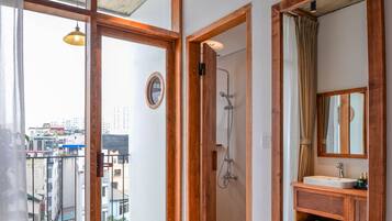 Une salle de bain moderne avec un meuble-lavabo en bois, un grand miroir et une douche.