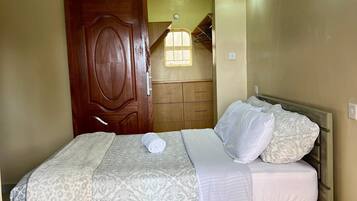 A bedroom with a wooden bed, a wooden nightstand, a wardrobe, and a ceiling light fixture.