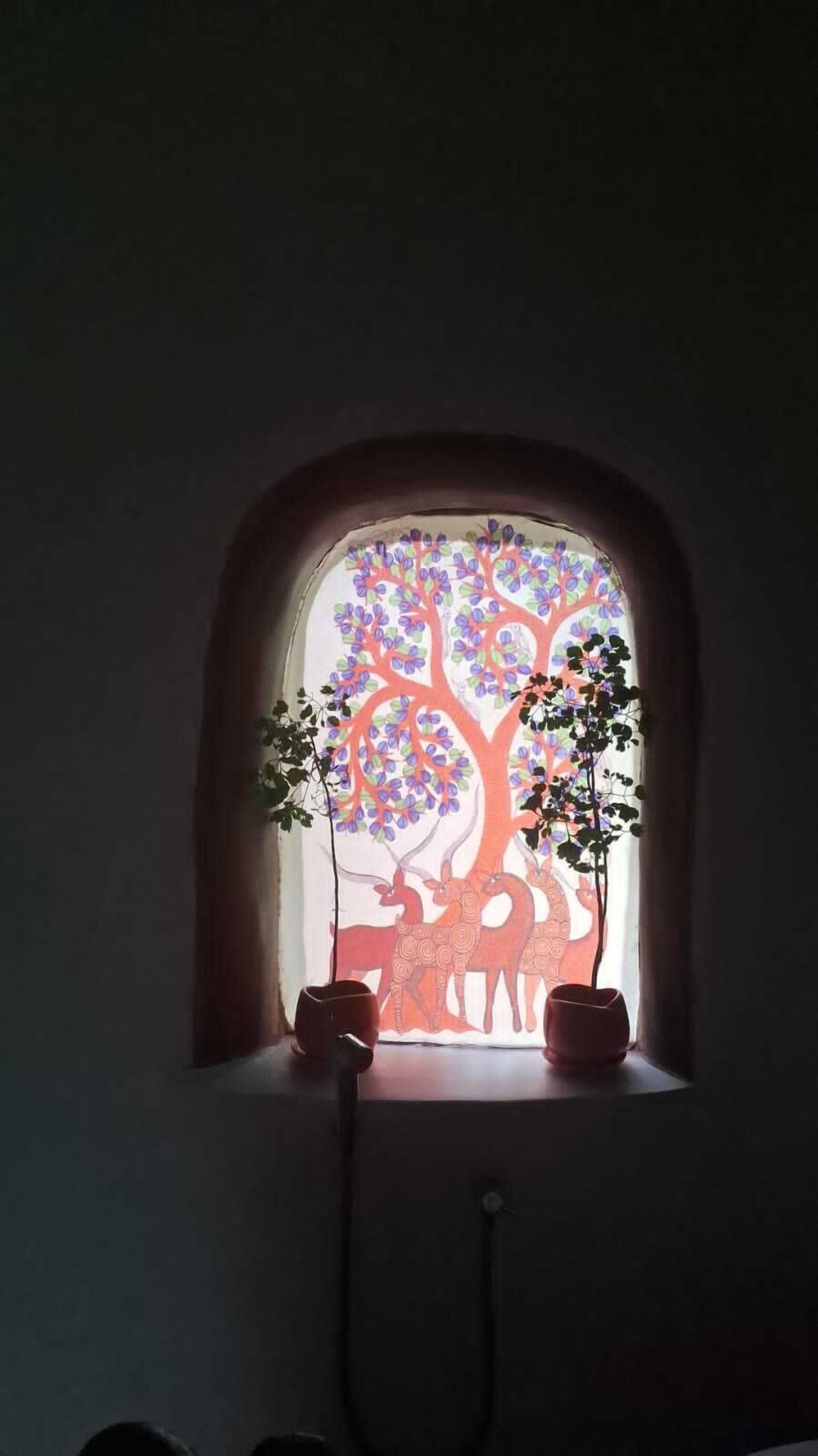 Una ventana con un árbol decorativo y silueta de ciervo.