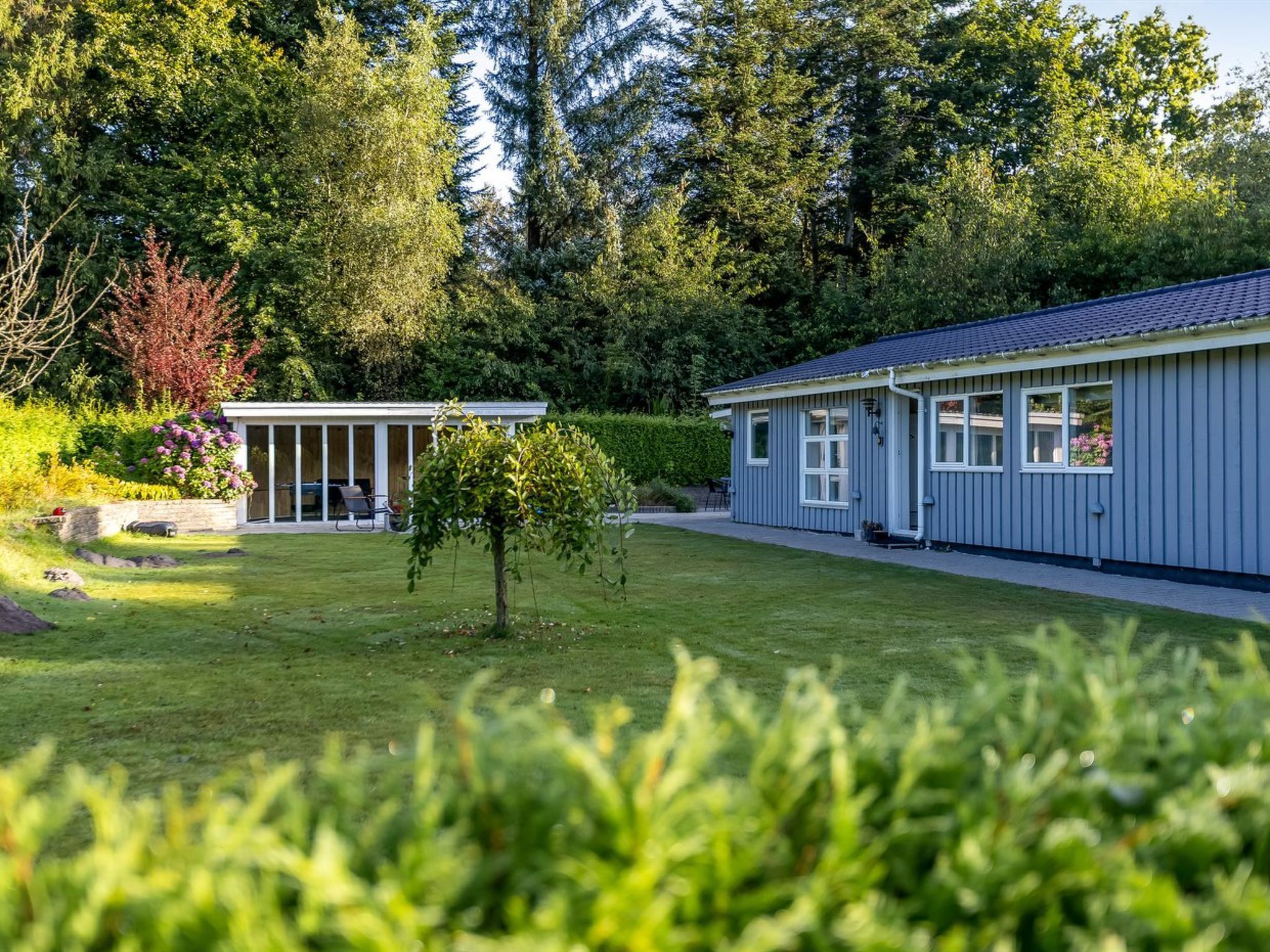 Un bâtiment à deux étages doté d’un patio couvert et d’un espace jardin.