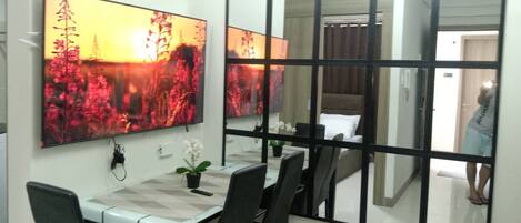 A dining area with a table, chairs, and a large mirror reflecting the room.