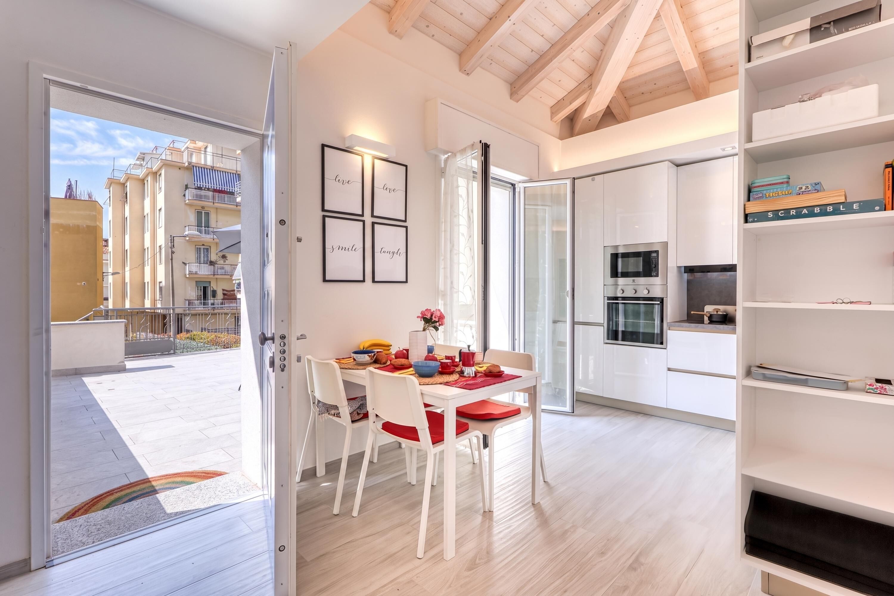 A modern kitchen with white cabinetry, a built-in oven, and a microwave.