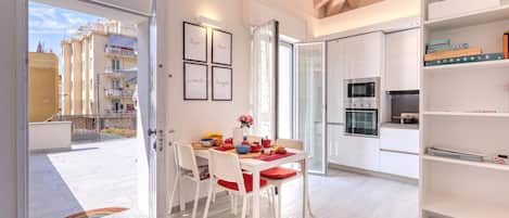 A modern kitchen with white cabinetry, a built-in oven, and a microwave.