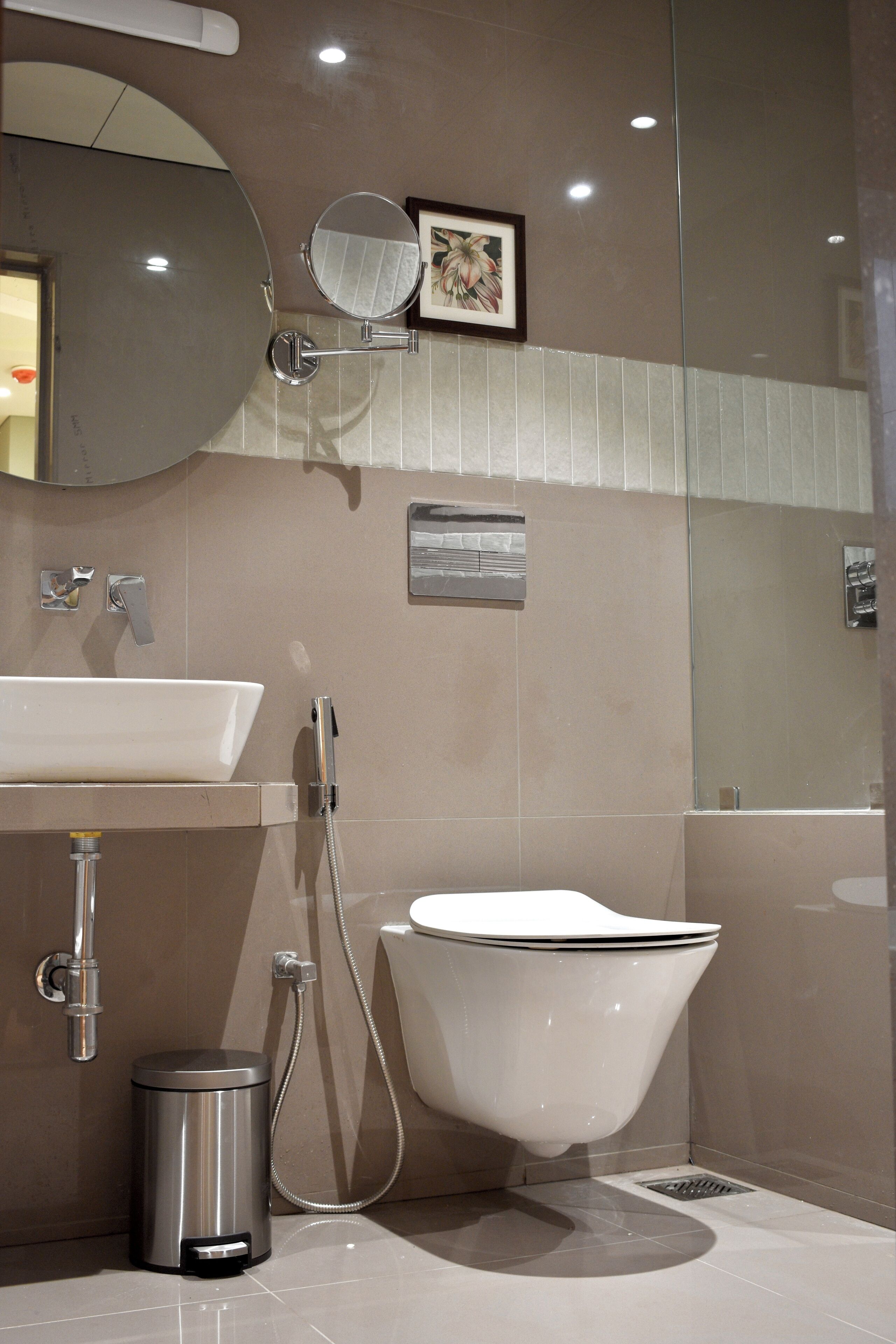 A modern bathroom with a freestanding bathtub, a sink, a mirror, and a trash can.