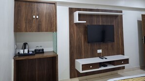 Een moderne woonkamer met inbouw houten kasten, een flatscreen televisie en een koffiehoek.