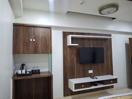 Una sala de estar moderna con armarios empotrados de madera, un televisor de pantalla plana y una estación de café.