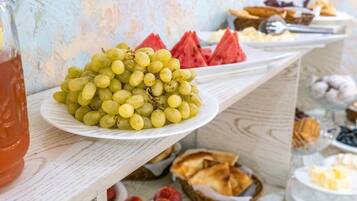 Ein Buffet mit verschiedenen Speisen, darunter Trauben, Wassermelone und andere Früchte.