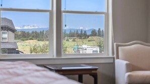A bedroom with a large window offering a view of a mountain range and a green field. - Fantastic High Desert Retreat, Pet Friendly, Fenced Backyard w/ Covered Patio, Ping Pong, BBQ (Bend)