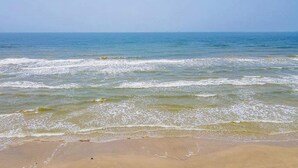 Een strand met golven die de kust naderen.
