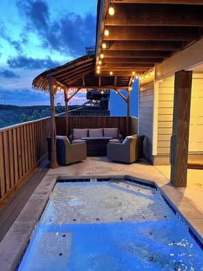 A covered outdoor area with a hot tub, seating, and string lights. - Our Last Sand Dollar~Private Pool~EV~Boardwalk (Port Aransas)