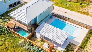 Een modern herenhuis met zwembad, een overdekt terras en uitzicht op een meer.