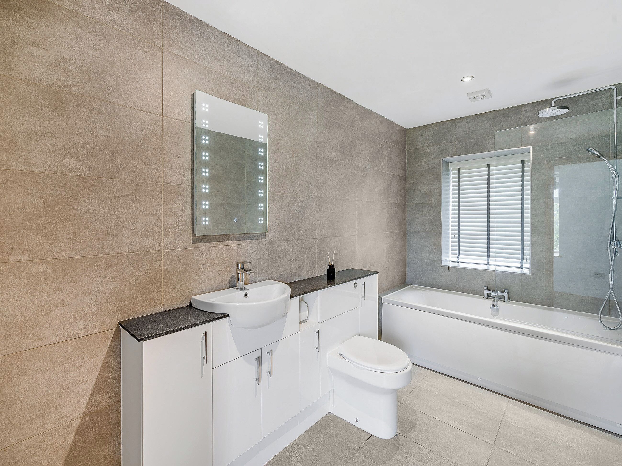 Un bagno moderno con lavabo, water, vasca e sanitari.