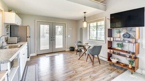 A modern kitchen with a dining area, wooden floors, and a large window. - Home w/ Lake Views on Finger Lakes Wine Trail (Penn Yan)