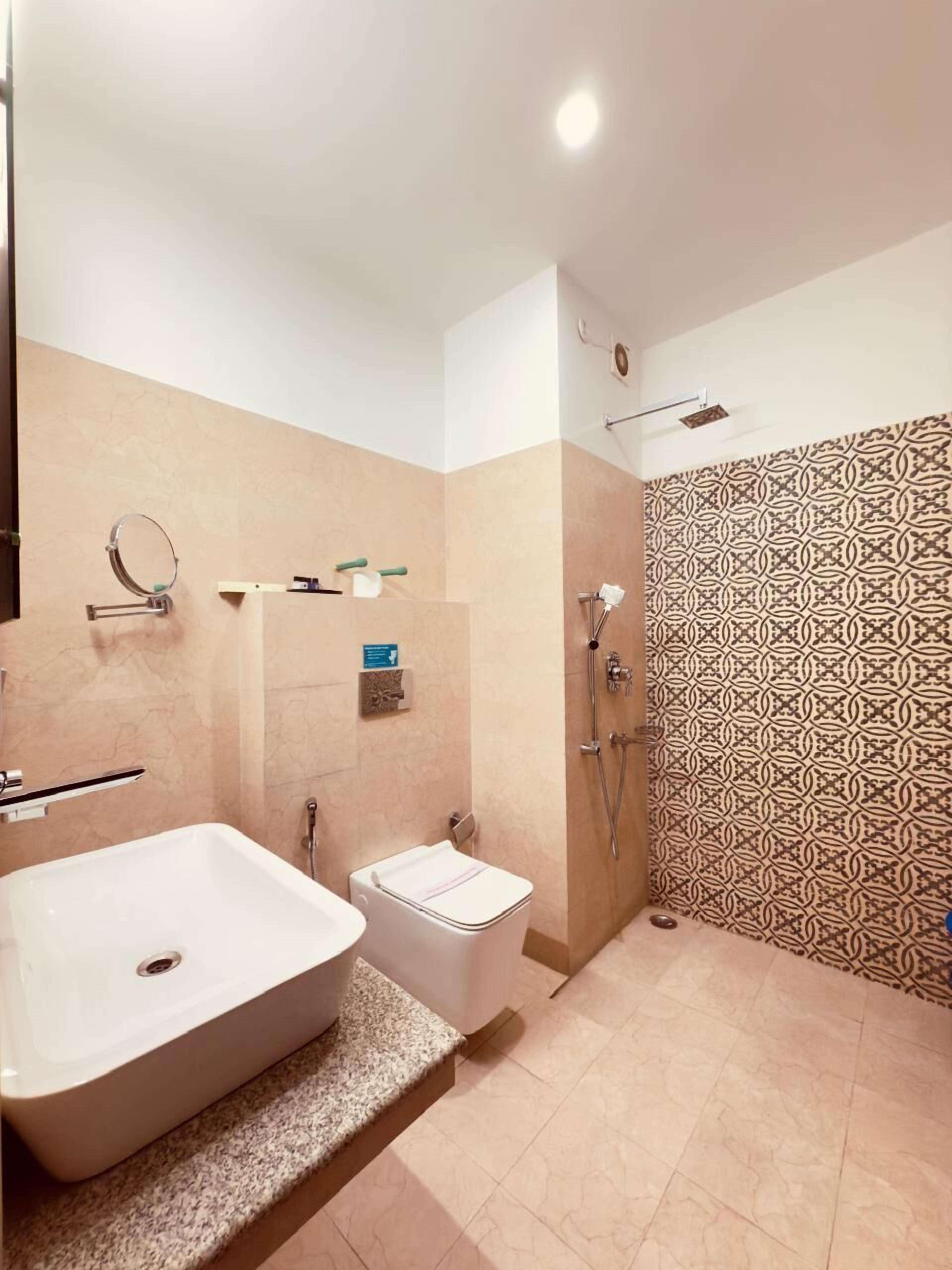 A bathroom with a large bathtub, a toilet, and a shower area.