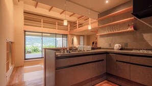 A modern kitchen with a large island, built-in appliances, and a view of the outdoors.