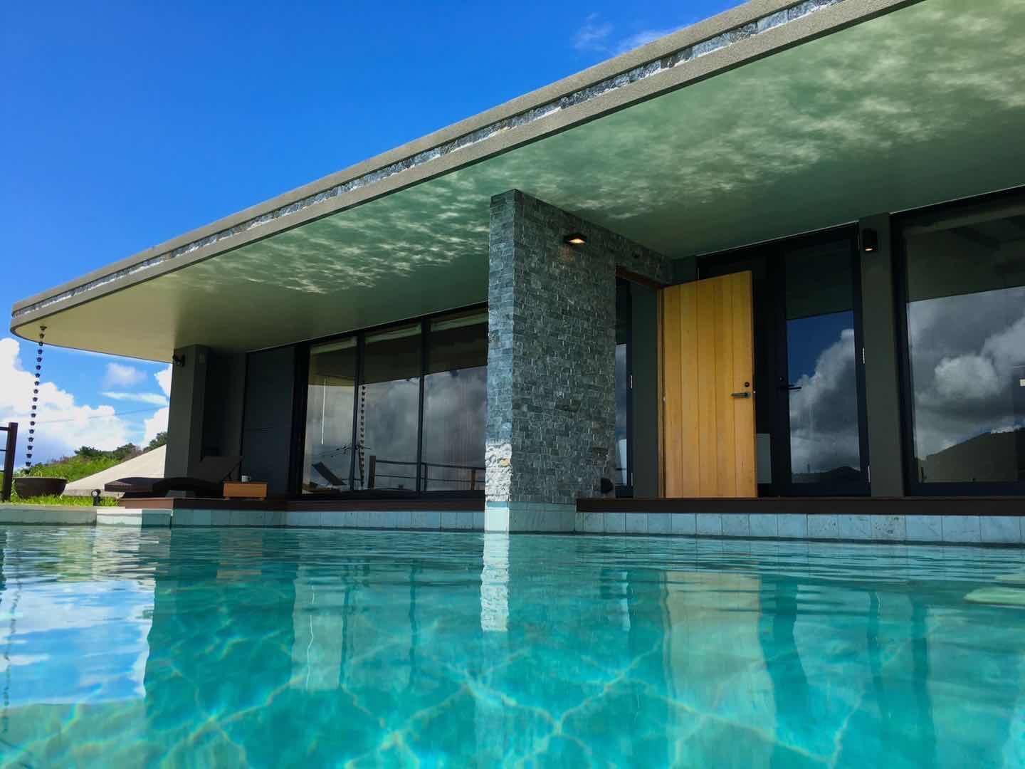 Um edifício moderno com piscina na frente.