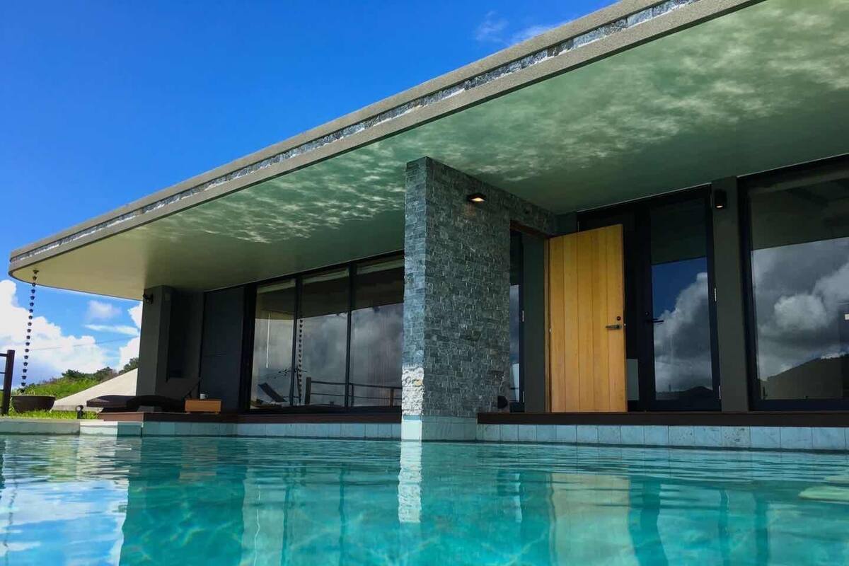 Un bâtiment moderne avec une piscine devant.