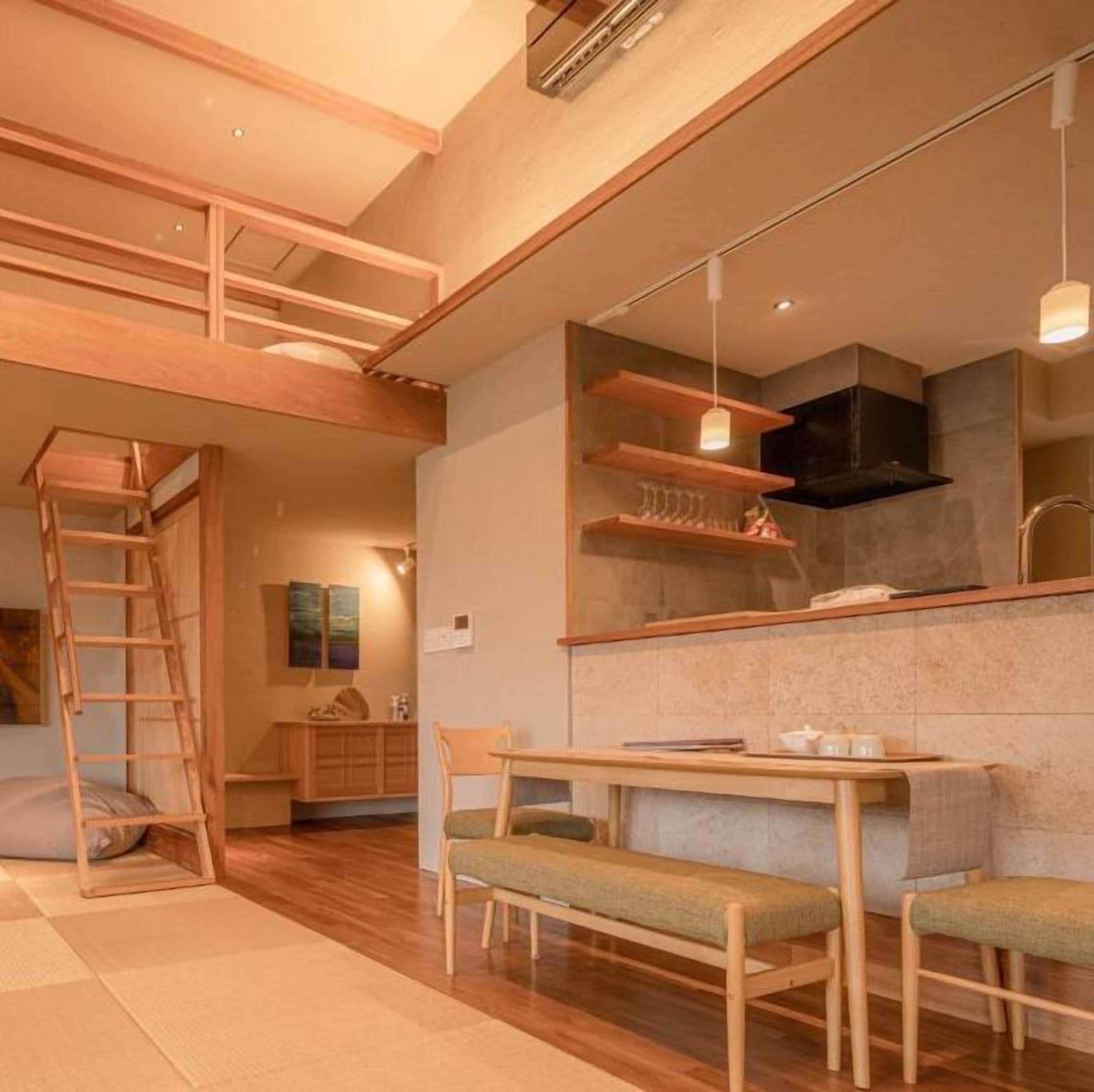 Um interior moderno com cama estilo loft, área de refeições e cozinha.