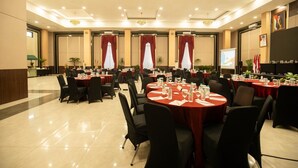 A conference room with round tables, chairs, and a projection screen. - Horison Ultima Sayaga Cibinong (Cibinong)