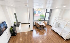 Une chambre d’hôtel moderne avec un coin repas, des lits superposés et une vue sur la ville.