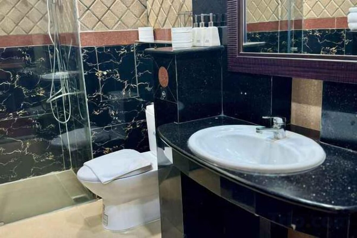 Casa de banho com sanita, lavatório e zona de duche.