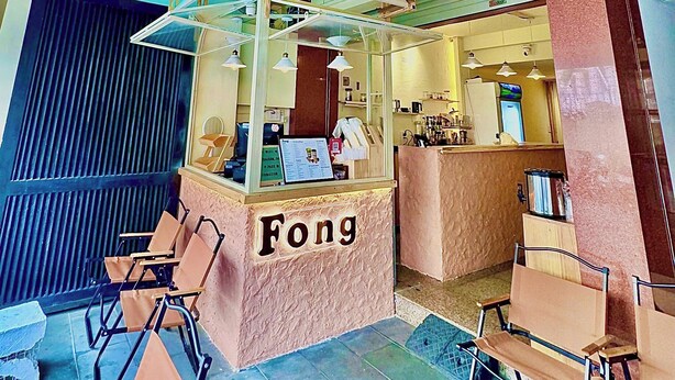 Aula, jossa on vastaanottotiski, jonka kyltissä lukee ”Fong”, istuimia ja näkymä sisätiloihin.