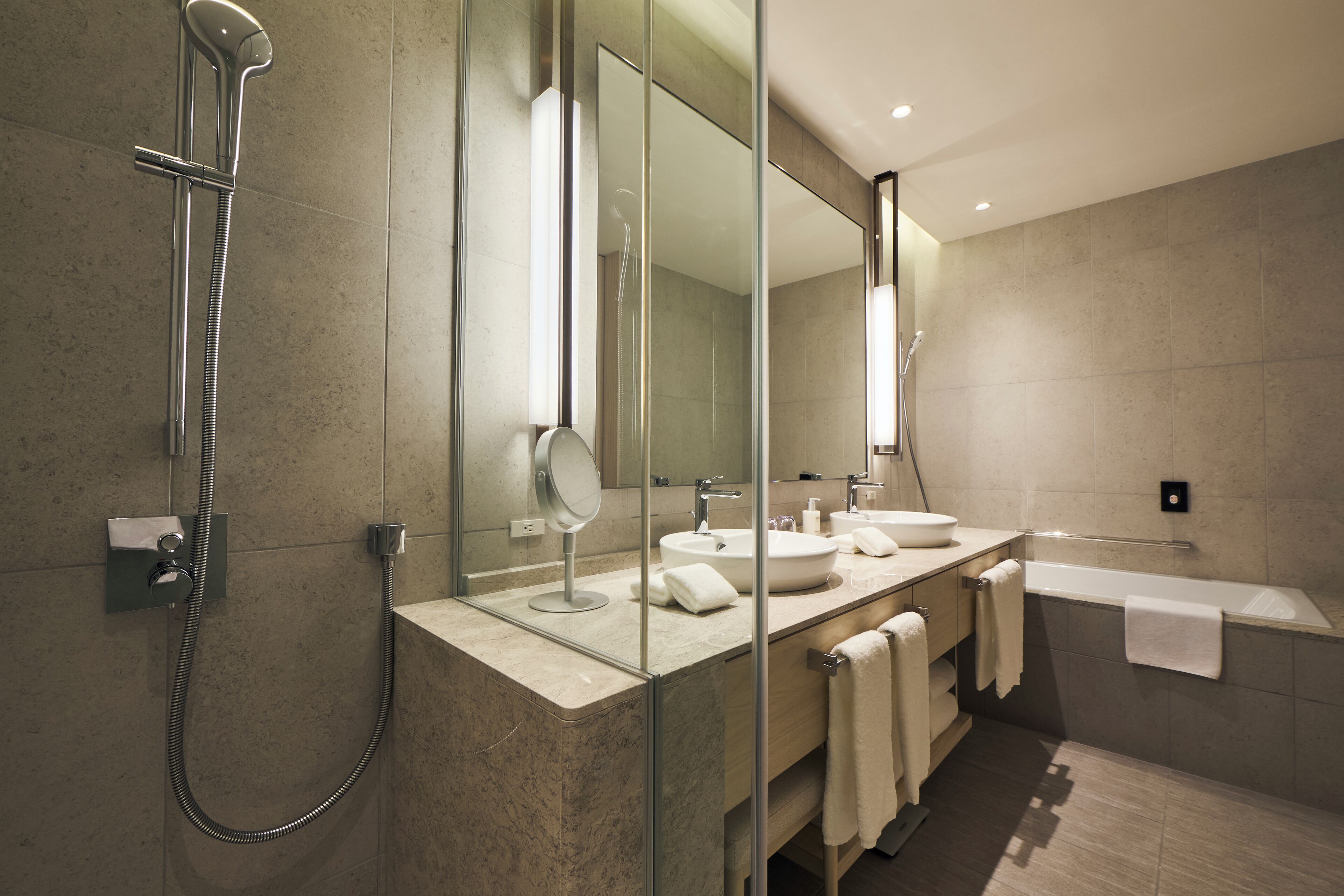 A modern bathroom with a glass-enclosed shower, a double sink vanity, and a large mirror.