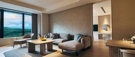 A modern living room with a sofa set, a coffee table, and a dining area.