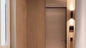 A modern elevator with a minimalist design, a visible door handle, and a wall-mounted light fixture. - Luxurious Suite - AC- 2P- Madeleine/saint Honore (Paris)
