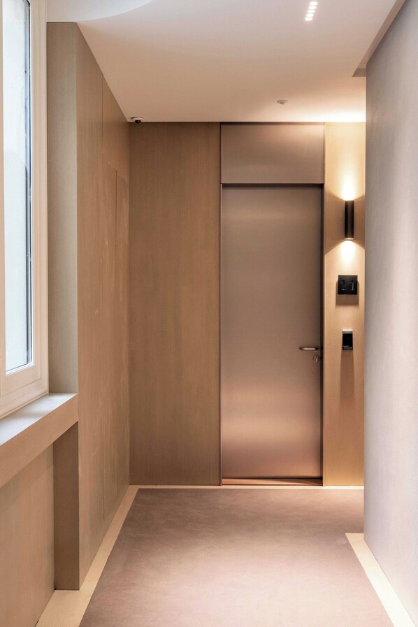 A modern elevator with a minimalist design, a visible door handle, and a wall-mounted light fixture. - Luxurious Suite - AC- 2P- Madeleine/saint Honore (Paris)