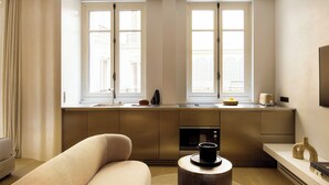 A modern kitchen with a built-in oven, a coffee machine, and a window with a view of a building. - Luxurious Suite - AC- 2P- Madeleine/saint Honore (Paris)
