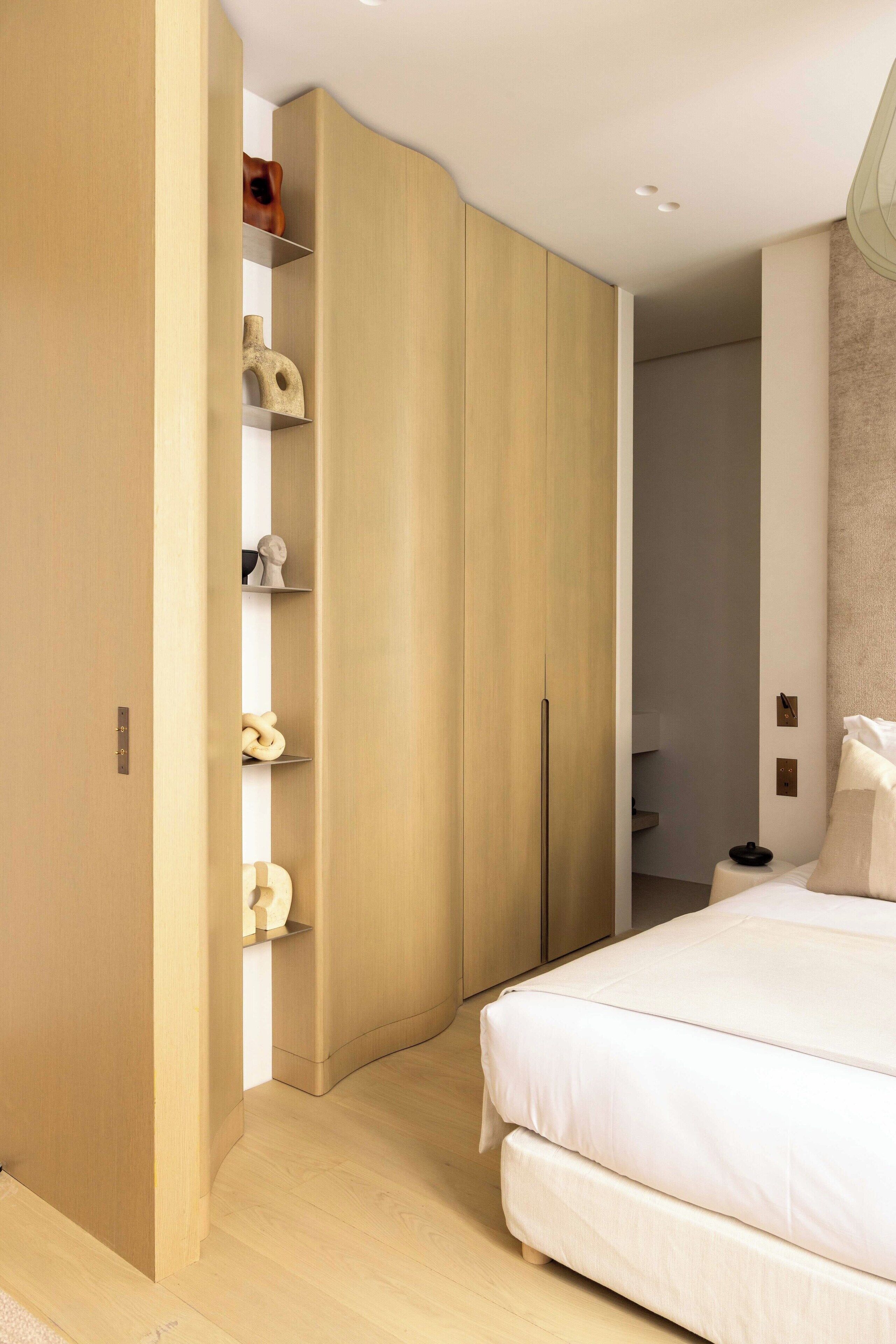 Une chambre à coucher comprenant un lit, une armoire et une étagère avec des objets décoratifs.
