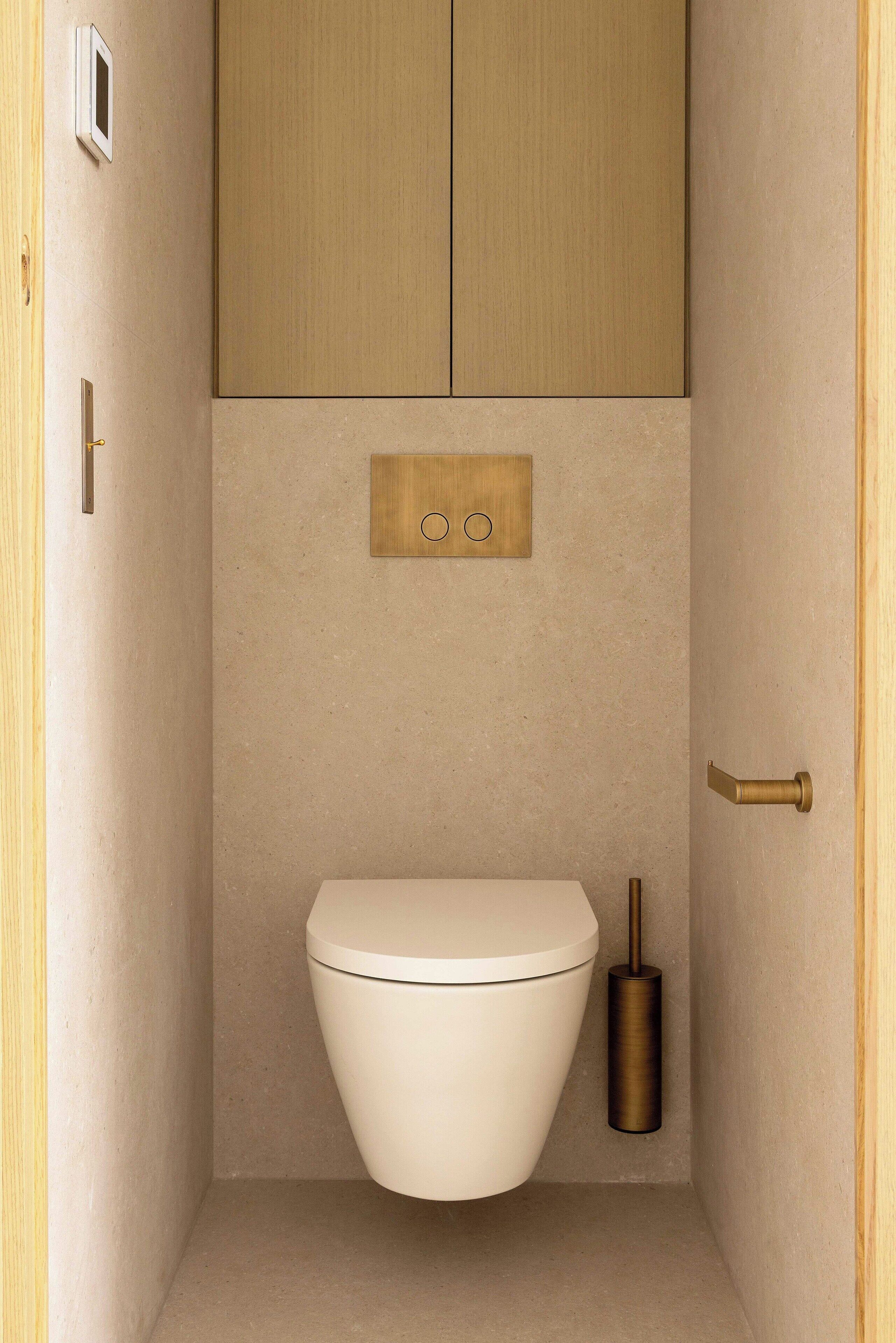 Een kleine, moderne badkamer met toilet, spoelhendel en spoelreservoir.