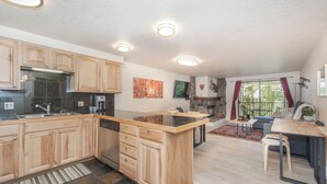 Een moderne keuken met houten kastjes, een centraal eiland en een stenen open haard.