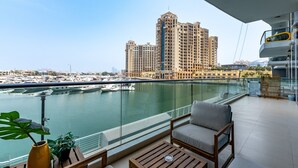 Een balkon met uitzicht op een jachthaven en een groot hotelgebouw.