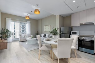 Un apartamento moderno con comedor, cocina y balcón con vista a la ciudad.
