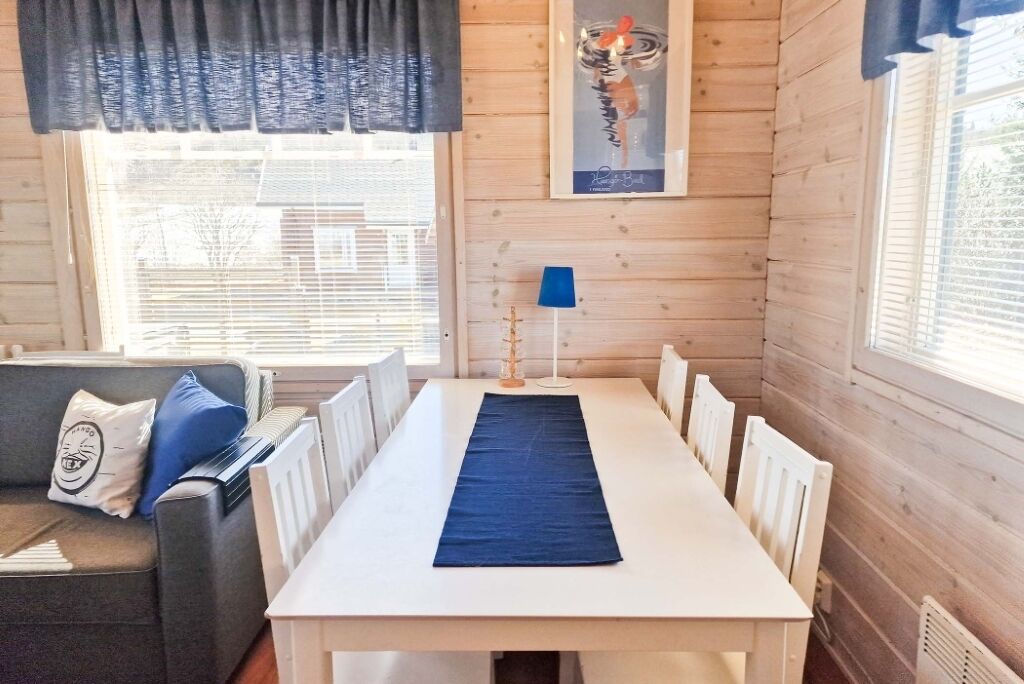 A room with a white table, blue runner, and a blue lamp.