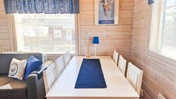A room with a white table, blue runner, and a blue lamp.