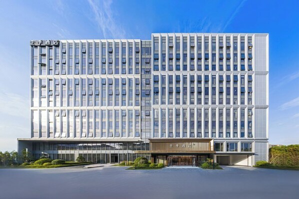 A modern hotel building with a symmetrical facade, multiple floors, and a central entrance. - Full Season Hotel-HGH (Hangzhou)