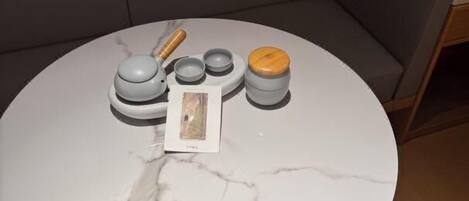 A round marble table with a small set of kitchen utensils and a card.