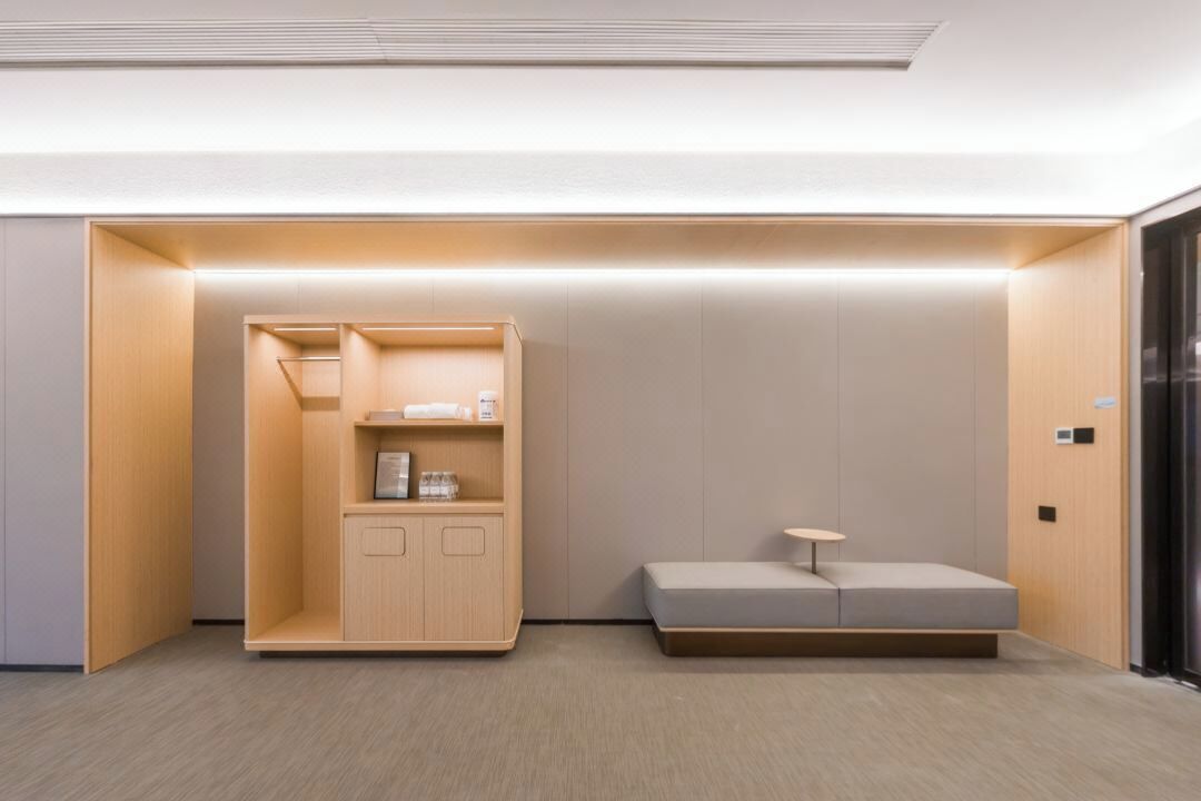 A modern, minimalist room with a built-in wooden cabinet, a bench, and a small table.