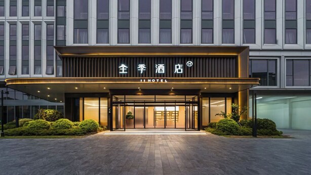 A hotel entrance with a modern facade, large glass doors, and a sign indicating it is a hotel. - Full Season Hotel-HGH (Hangzhou)